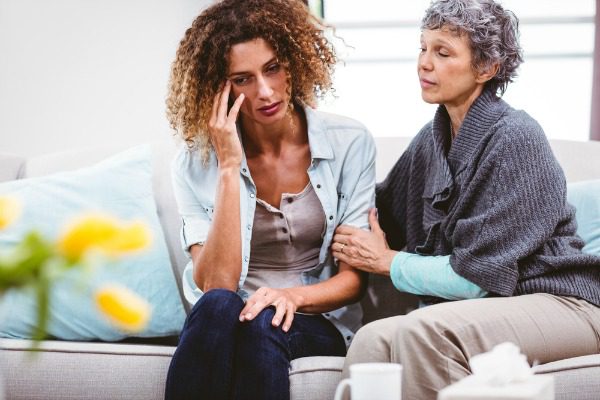 Mother comforting addict daughter