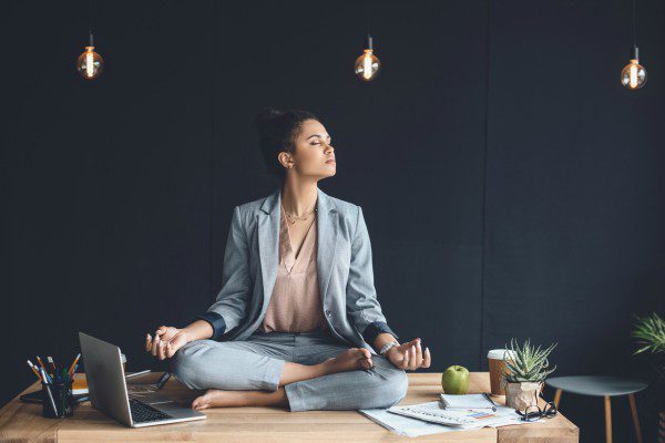 Meditating woman on office desk